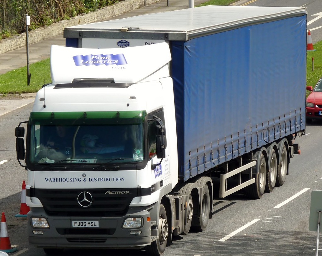 Ein Mercedes Actros Sattelzug mit 'Park Logistics' Branding auf einer Autobahn.